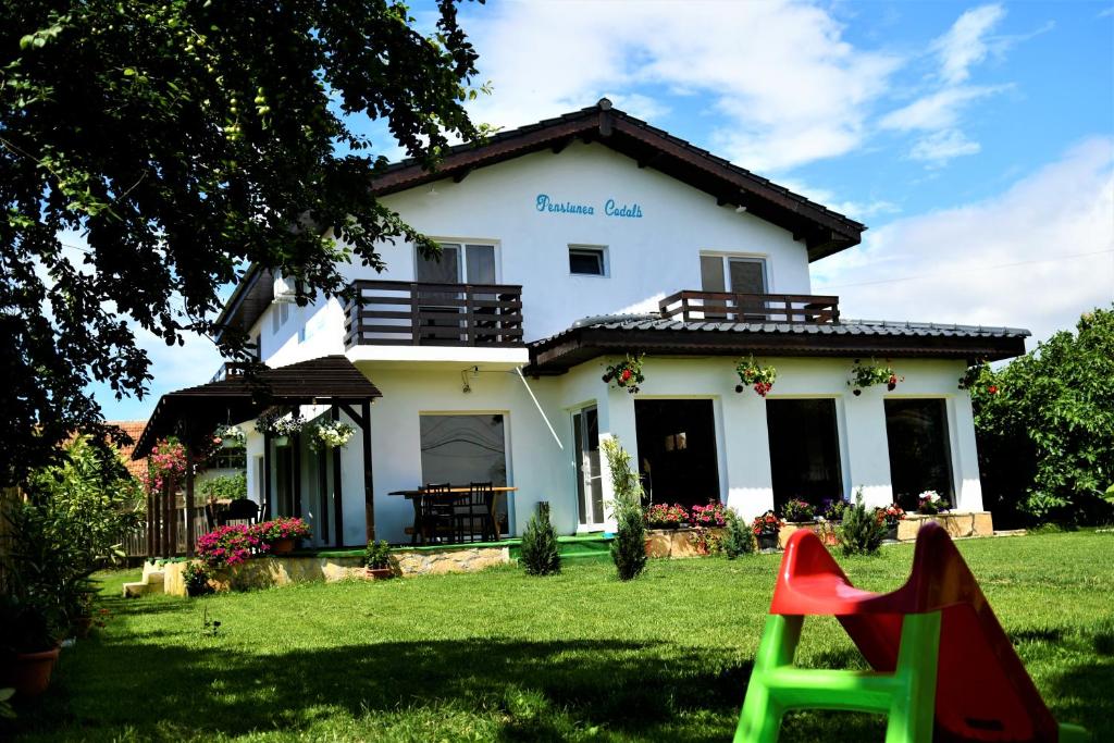 una casa con un parque infantil delante de ella en Pensiunea Codalb, en Jurilovca