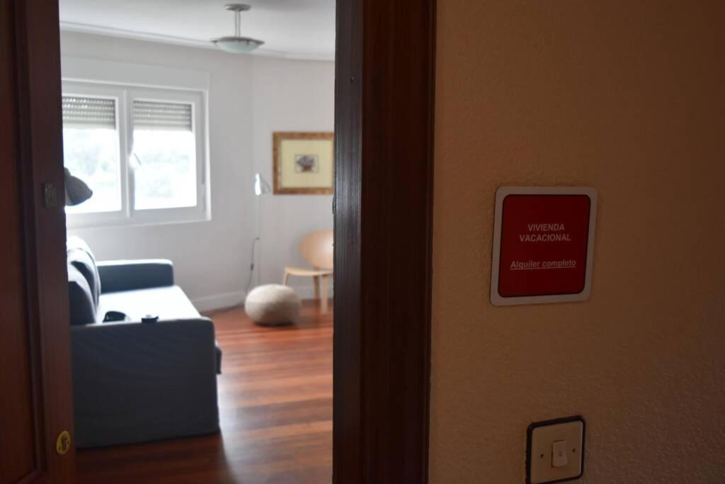 uma sala de estar com um sofá azul e um sinal para não fumadores em Apartamento cerca de la playa em Santander