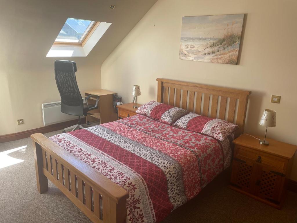 a bedroom with a bed and a chair and a window at Riverside apartments Westport in Westport