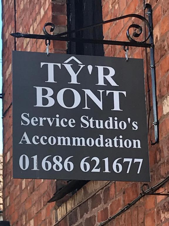 a sign on the side of a brick building at Ty'r Bont Studios in Newtown