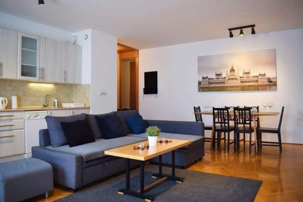 een woonkamer met een blauwe bank en een tafel bij Cosy Apartment In Budapest Downtown WITH Free Garage Parking in Boedapest