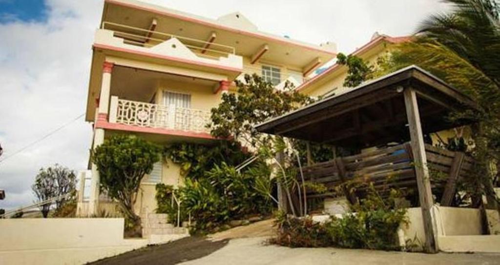 uma casa com um alpendre e uma varanda em Casa Robinson Guest House em Culebra