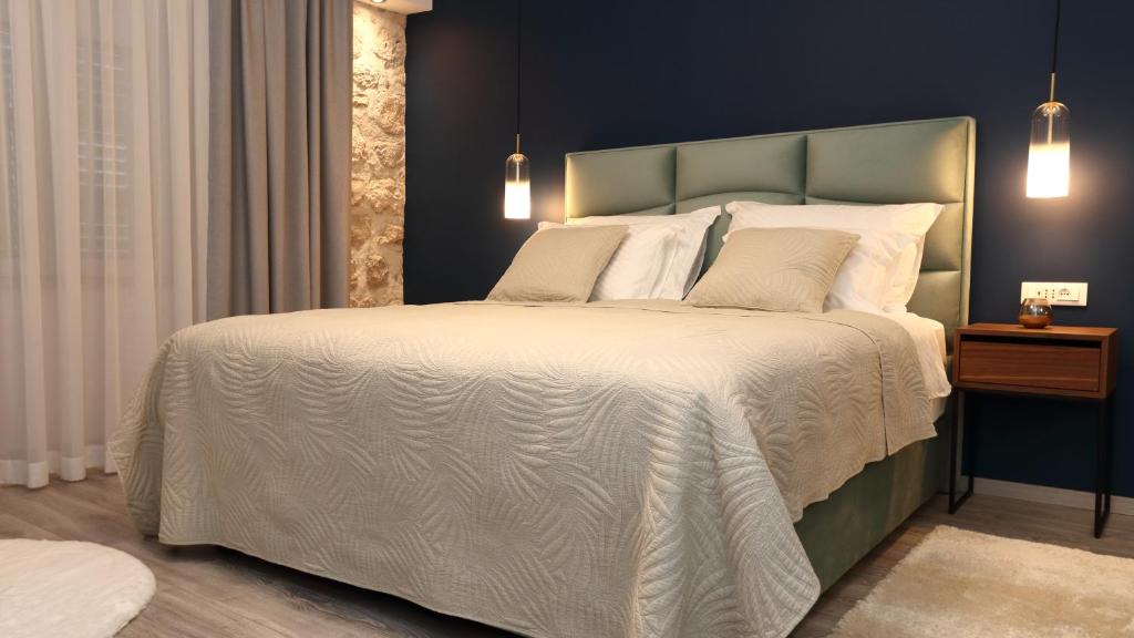 una camera da letto con un grande letto con lenzuola bianche di Etal Luxury Rooms a Dubrovnik