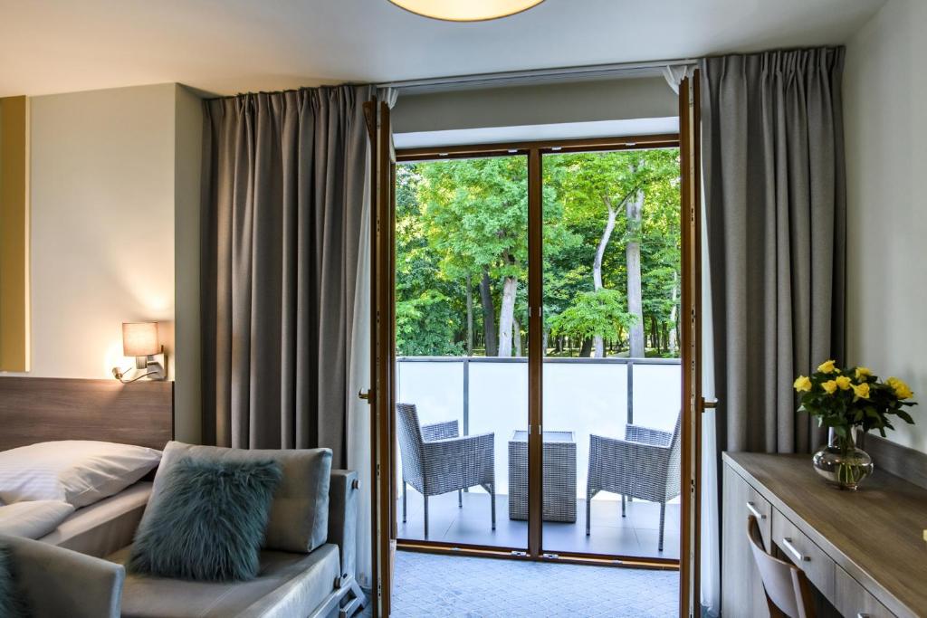 a hotel room with a bed and a balcony at Hotel Brzozówka in Busko-Zdrój