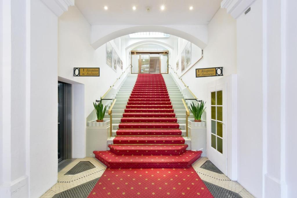 uma escada em alcatifa vermelha com um tapete vermelho em J5 Hotels Helvetie & La Brasserie em Montreux