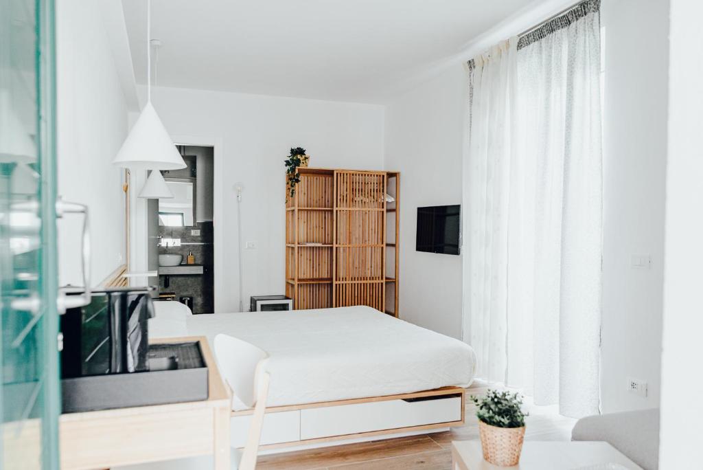 Habitación blanca con cama y TV en Le Camere di Giò, en Ameglia