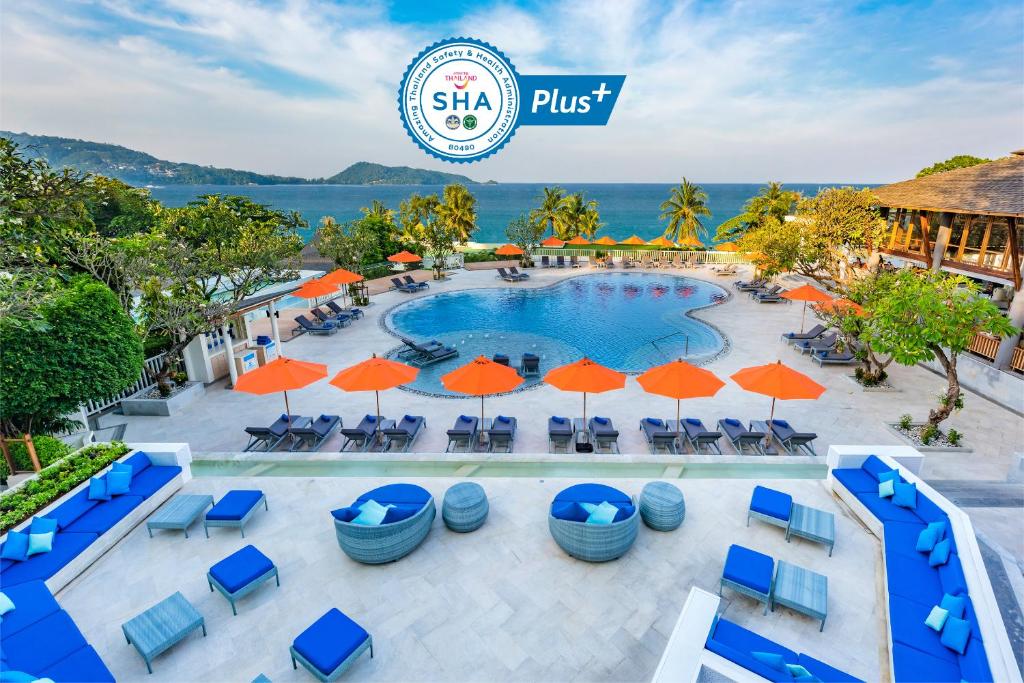 a swimming pool with several tables and umbrellas at Diamond Cliff Resort & Spa - SHA Extra Plus in Patong Beach