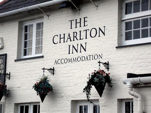 布蘭德福爾德福魯姆的住宿－The Charlton Inn，白色砖砌建筑,上面有标志