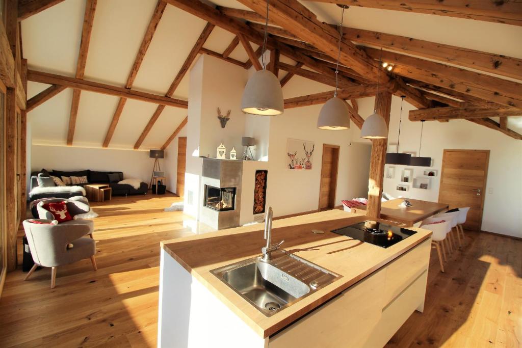 ヴェステンドルフにあるAlpenloft by Apartment Managersの木製の天井のキッチン&リビングルーム