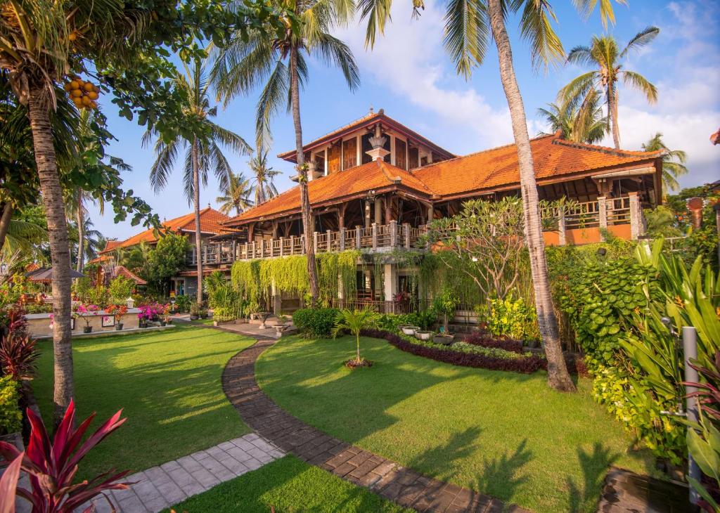 einen Blick nach außen auf ein Haus mit Palmen in der Unterkunft Nugraha Lovina Seaview Resort & Spa in Lovina