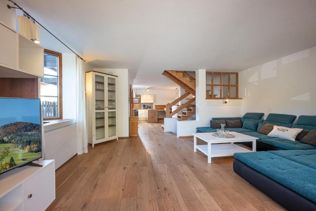 a living room with a blue couch and a tv at Chalet Gaisberg by Apartment Managers in Kirchberg in Tirol