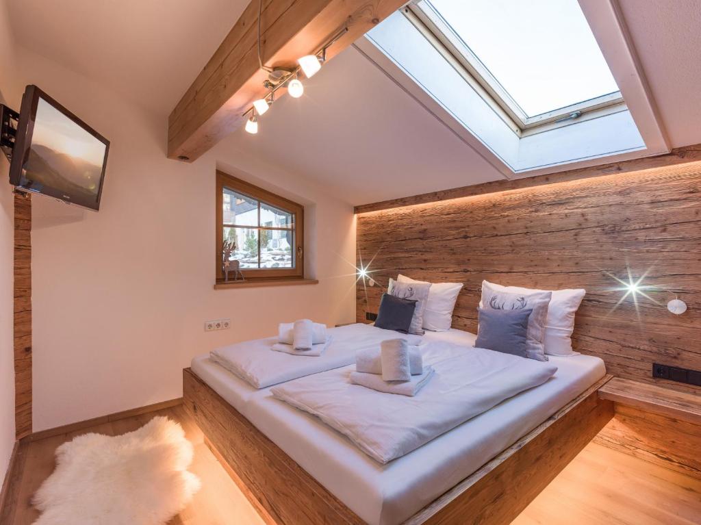 a bedroom with a large bed with a skylight at Chalet Weinberg Top 1 & Top 2 by Apartment Managers in Kirchberg in Tirol