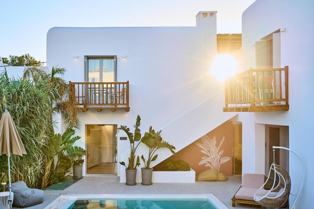 una casa con piscina in un cortile di Adorno Beach Hotel and Suites a Ornos