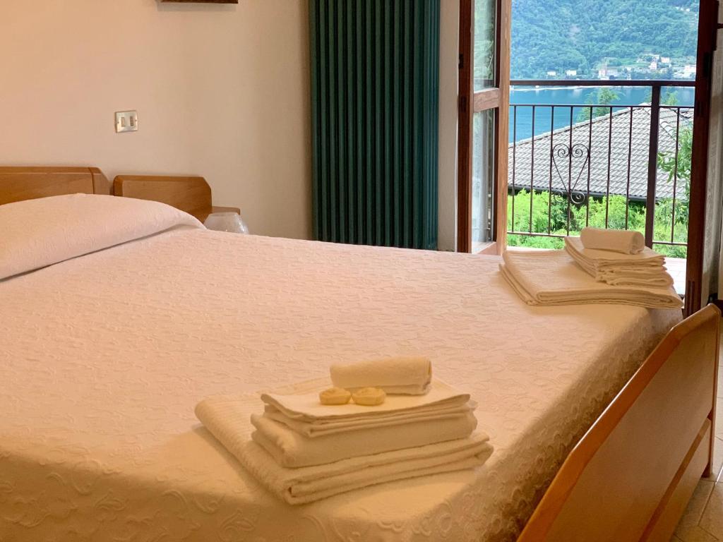a bedroom with a bed with towels and a window at Reginaldo's home Bed&Breakfast in Nesso