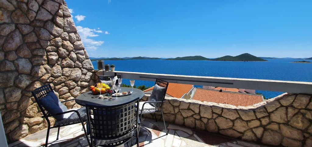 a balcony with a table and chairs and the water at Villa Marica & Joso in Drage