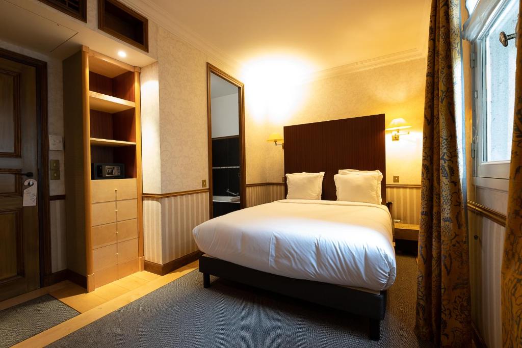 a hotel room with a bed and a window at Hôtel Relais Monceau in Paris