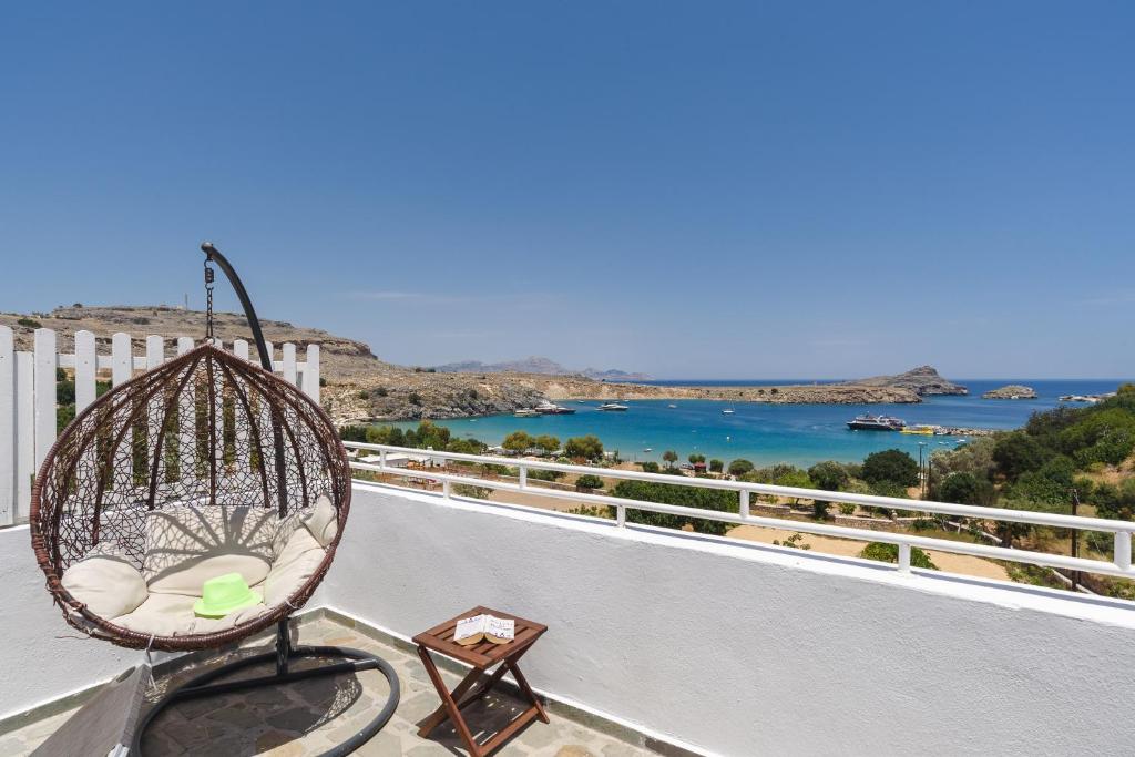 a swing on a balcony with a view of the ocean at Thea Villas and Suite in Líndos