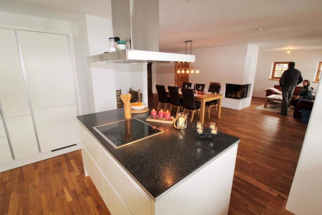 a kitchen with a black counter top and a living room at Apartment Jochberg by Apartment Managers in Jochberg