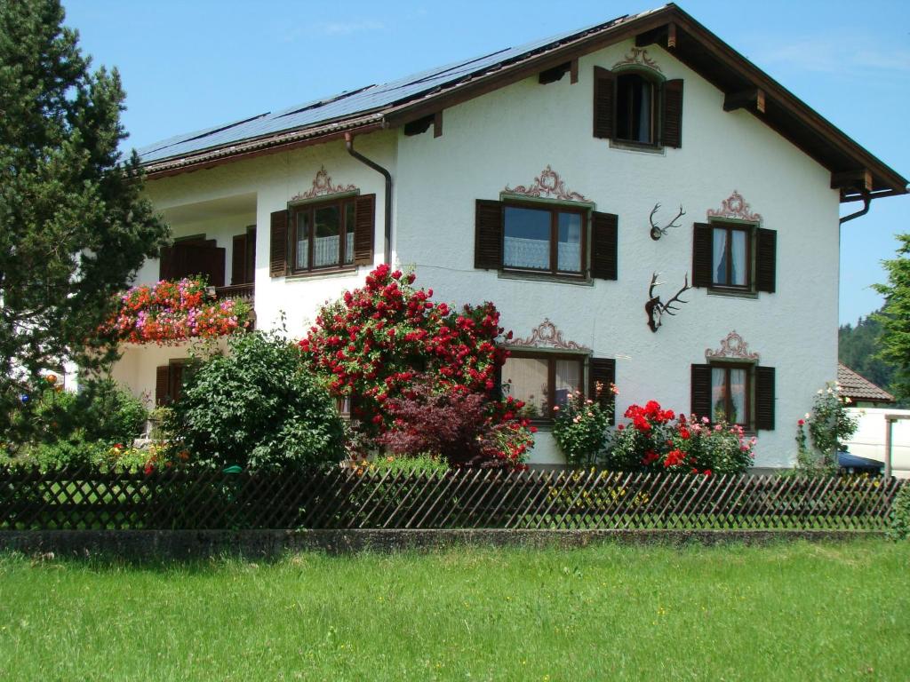 a white house with flowers in front of it at Gästehaus St. Bartholomä in Samerberg