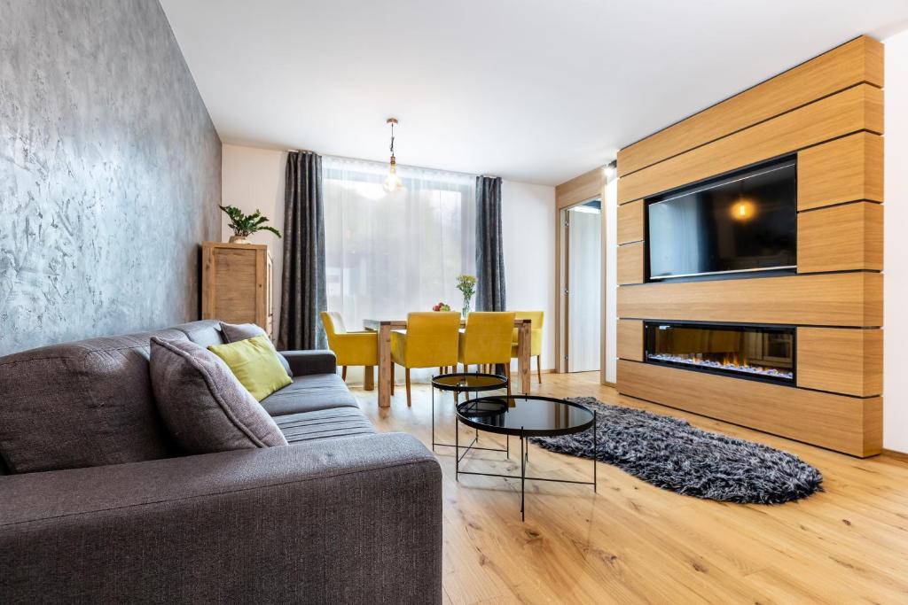 a living room with a couch and a tv and a table at RV Apartment Sapphire in Starý Smokovec