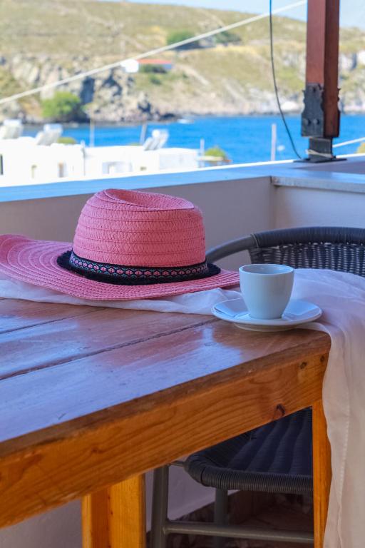 a pink hat sitting on a table with a cup at Mistral-Patmos in Patmos