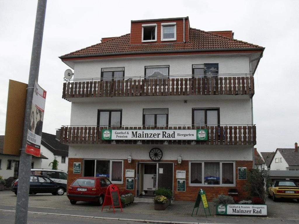 ein weißes Gebäude mit Balkon darüber in der Unterkunft Gasthof und Pension Mainzer Rad in Schwetzingen