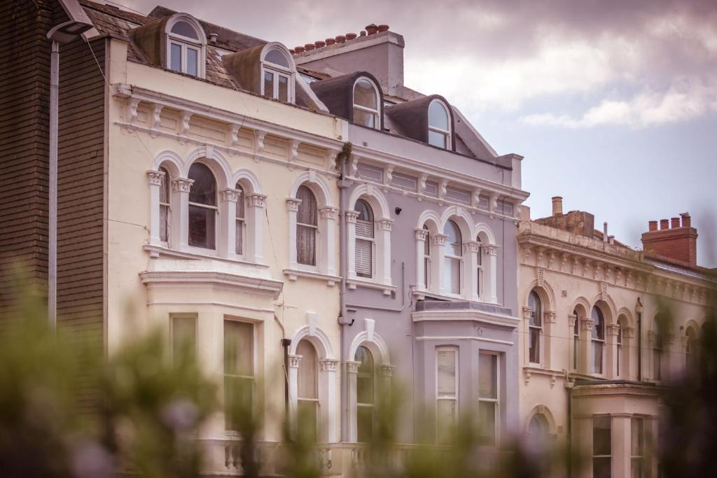 um grande edifício branco com muitas janelas em Artist's Loft - stylish 1-bed just 5 mins stroll from the beach em St. Leonards