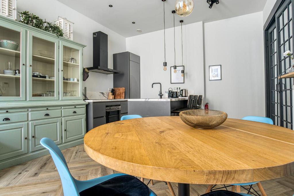 a kitchen with a wooden table and blue chairs at Hosted by Wendy Prins Willem 1 in Scheveningen