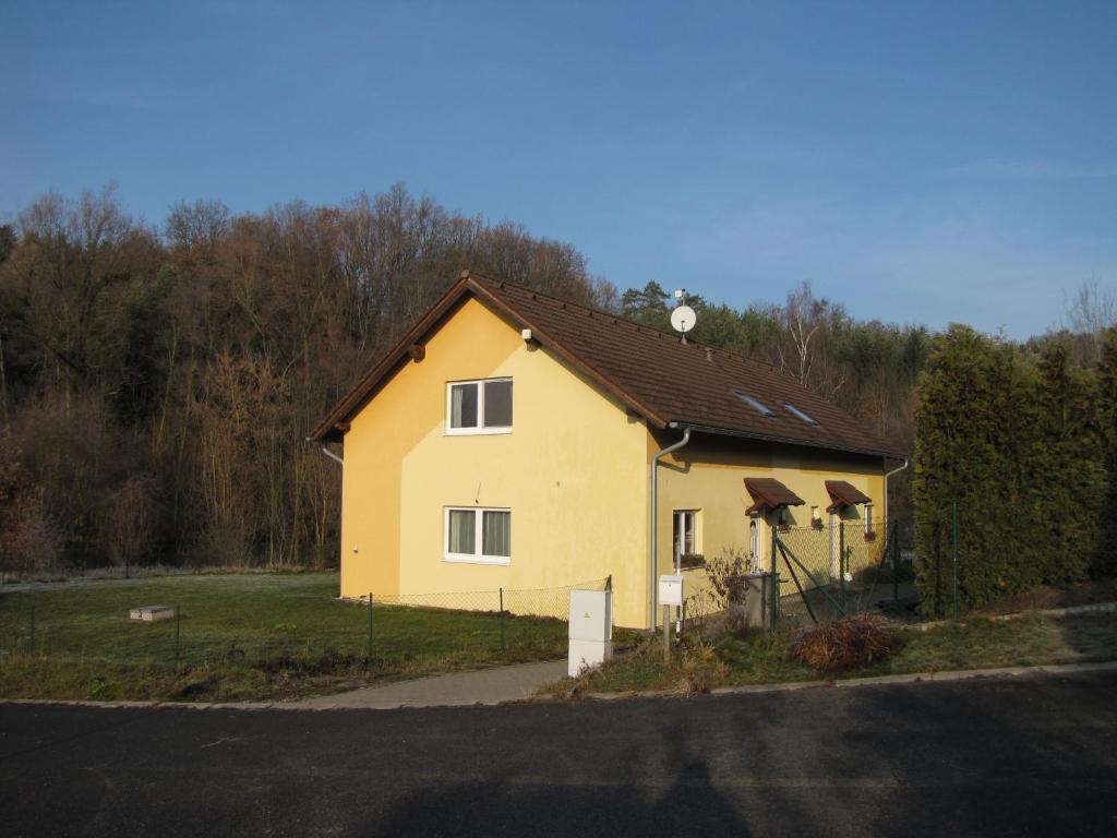 una casa amarilla al lado de una carretera en Apartmán Meduňková en Zlín