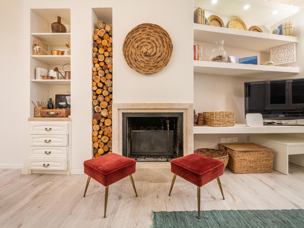a living room with two red chairs and a fireplace at Marco's stylish home In the heart of Cagliari in Cagliari
