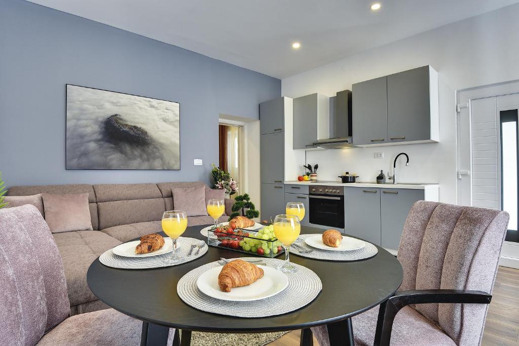 una sala de estar con una mesa con comida. en D&A Central Luxury Apartments with FREE Parking, en Pula