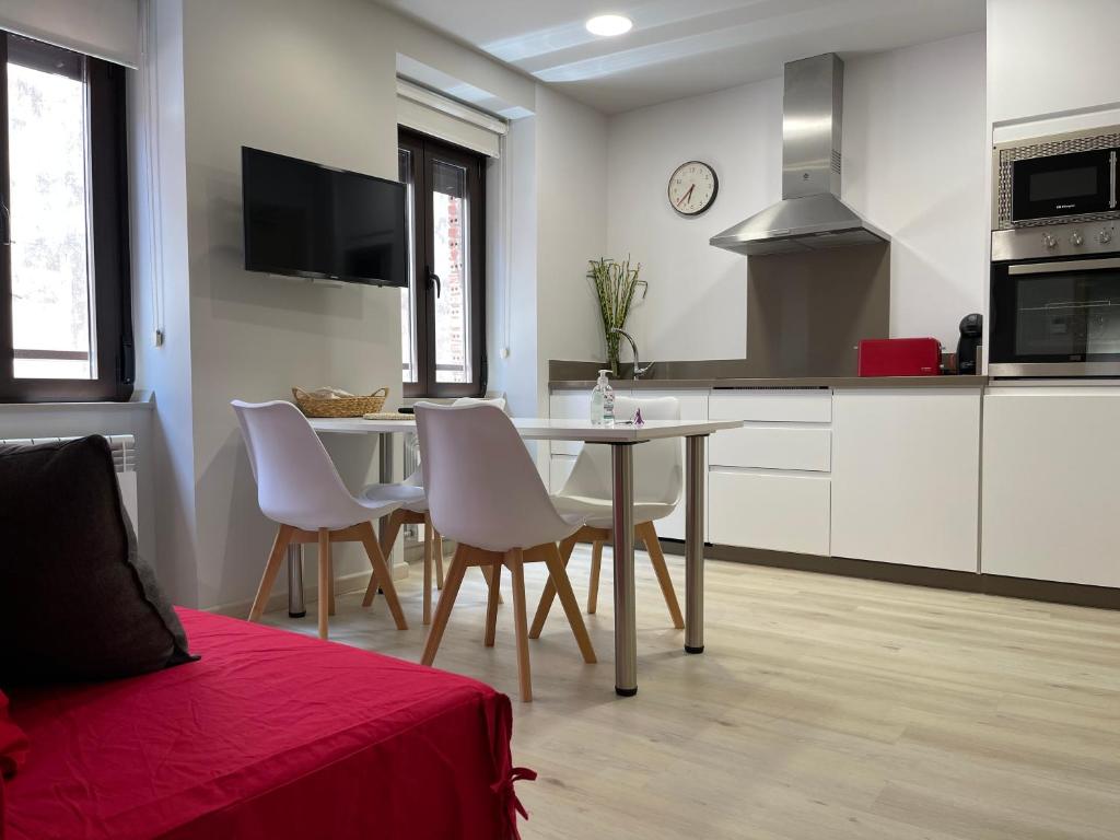 Apartamentos Puertas del Orbigo في Carrizo de la Ribera: مطبخ وغرفة طعام مع طاولة وكراسي