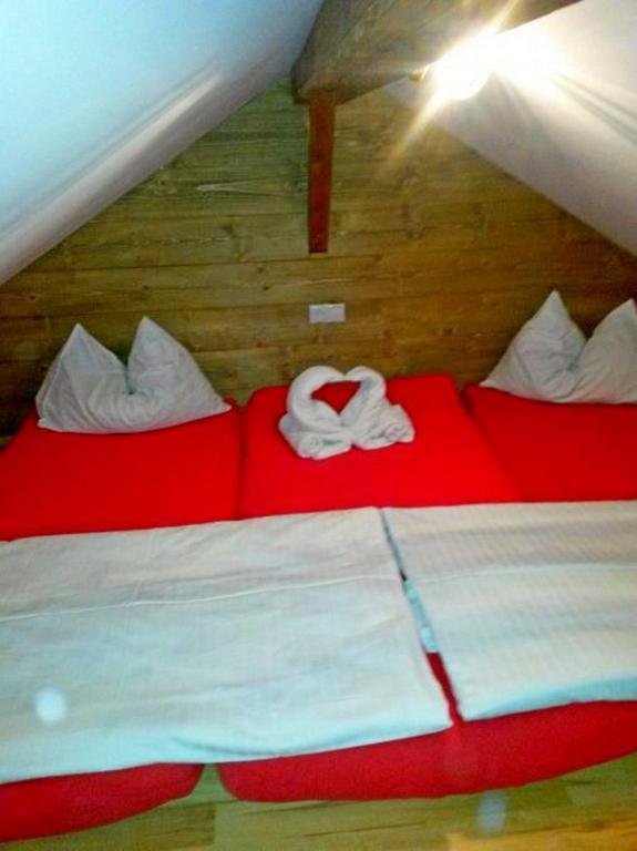 a bedroom with two red beds with white pillows at Ferienhaus Ematberg in Niedernsill