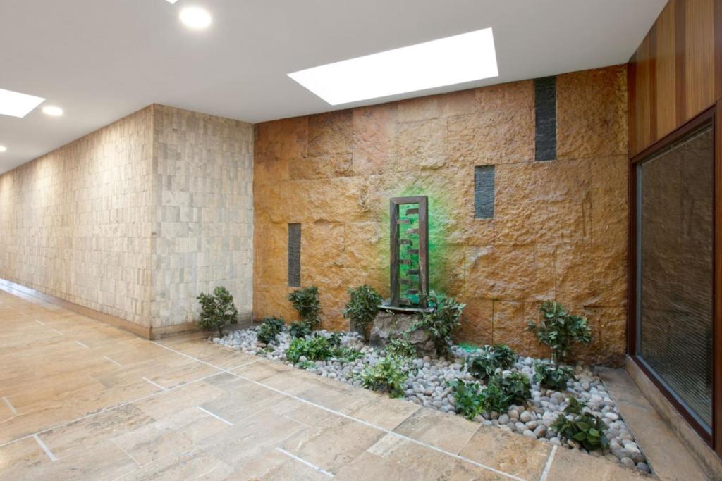 a lobby with a stone wall and a plant at Cozy studio 10 min from Eiffel Tower Invalides Beaugrenelle in Paris