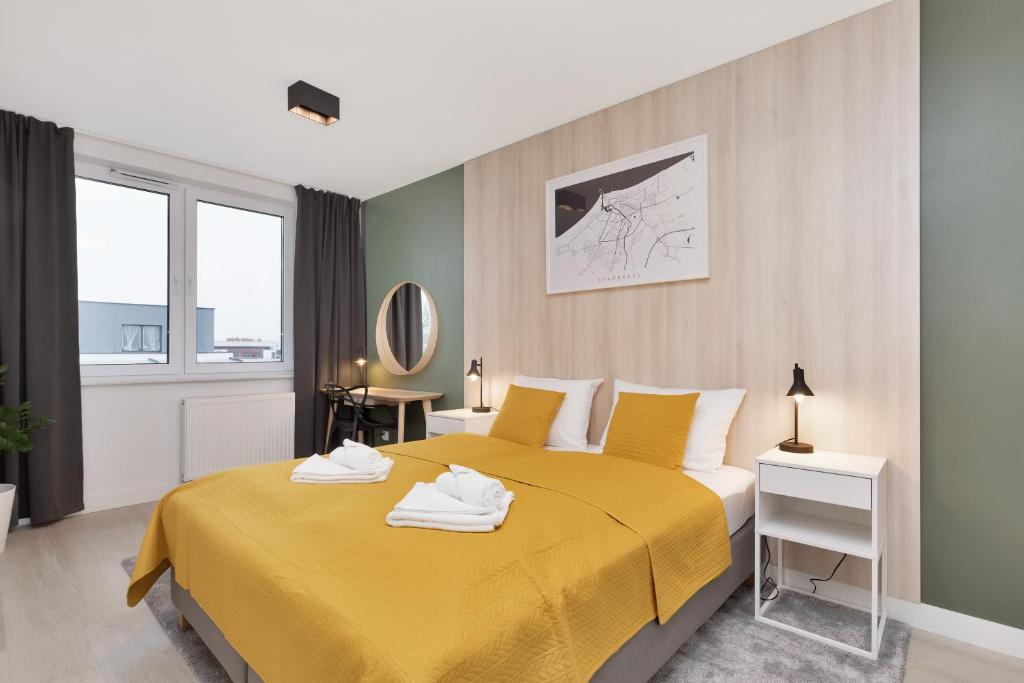 a bedroom with a yellow bed with a yellow blanket at Apartament Premium Platany by Renters in Kołobrzeg