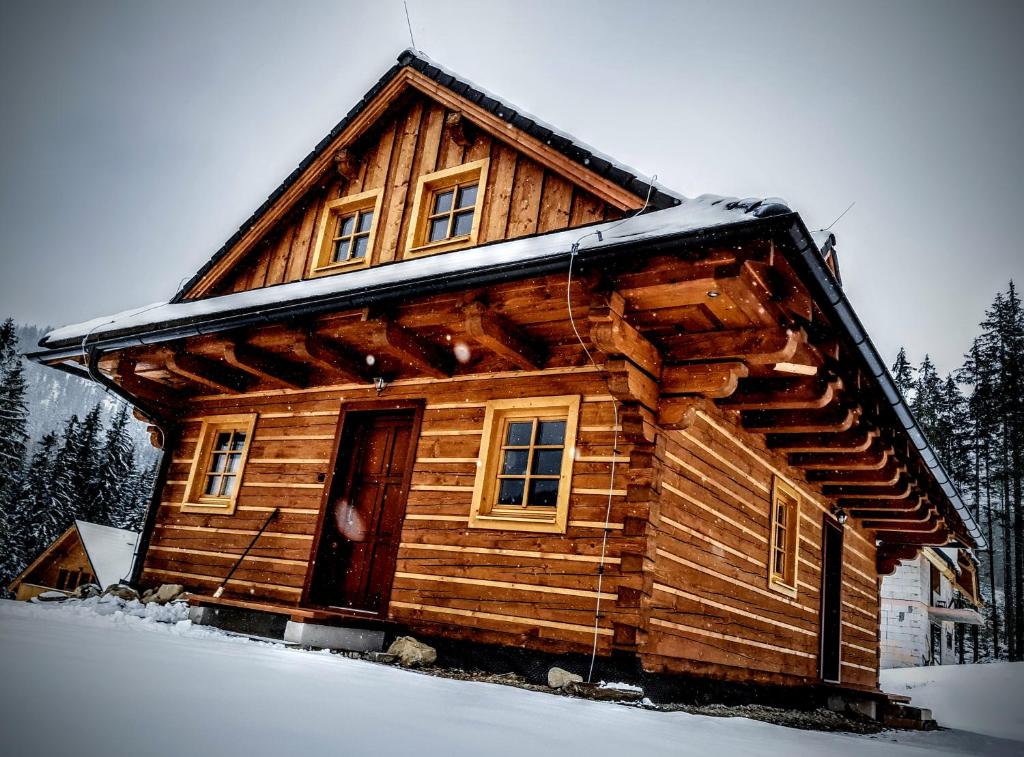 a log cabin in the snow with a door at Chalúpka na Lúke in Liptovský Mikuláš