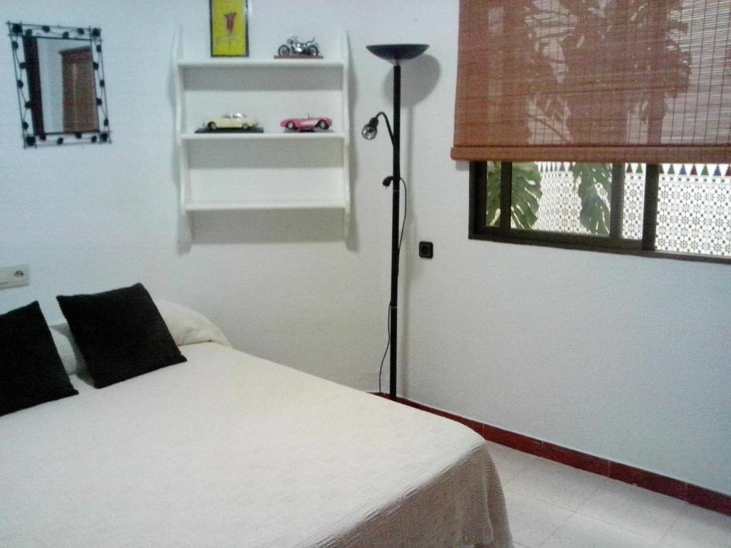 a bedroom with a white bed and a window at Casa Las Lomas in Prado del Rey