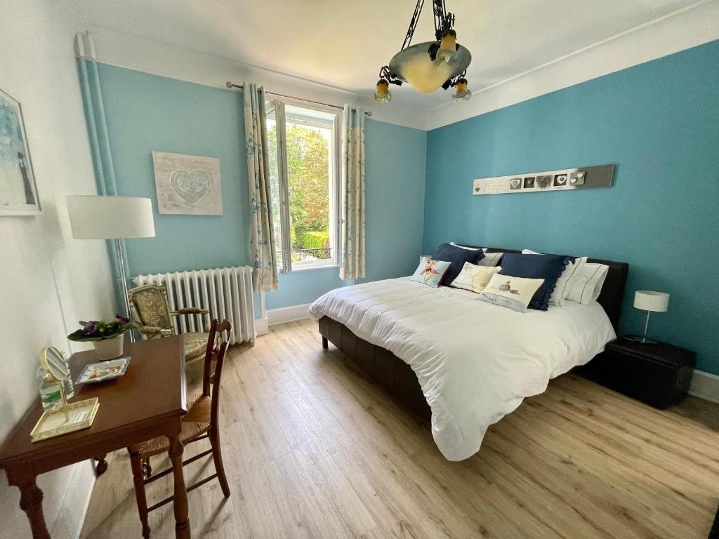 La Maison Bleue « La Charade » في تون ليه فوج: غرفة نوم بجدران زرقاء وسرير ومكتب