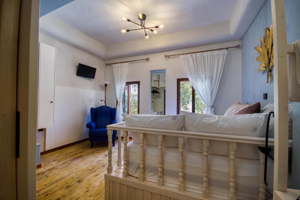 a bedroom with a bed and a blue chair at Bastion Luxury Medieval Accommodation in Rhodes Town