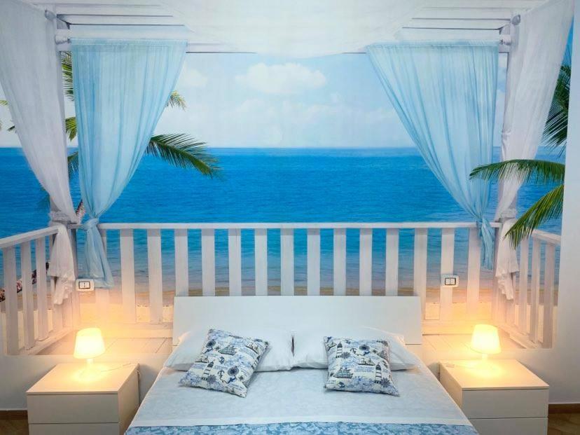 um quarto com uma cama e vista para o oceano em Nammuratè - Casa Vacanze em Nápoles