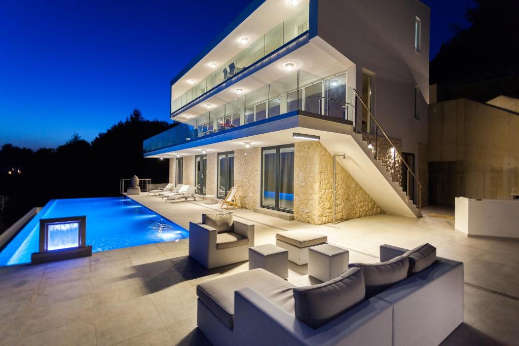ヴェラ・ルカにあるVilla Style and Seaの夜間のスイミングプール付きの大きな家