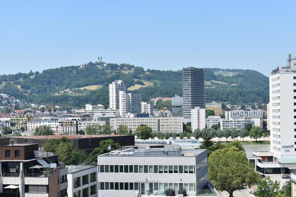 Blick auf eine Stadt mit hohen Gebäuden in der Unterkunft SOVEA Hotel - City in Linz