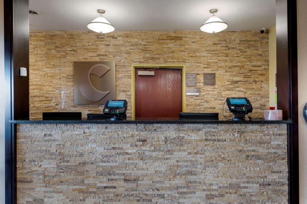 un vestíbulo con una pared de ladrillo y dos salas de espera en Comfort Suites Miamisburg - Dayton South, en Miamisburg