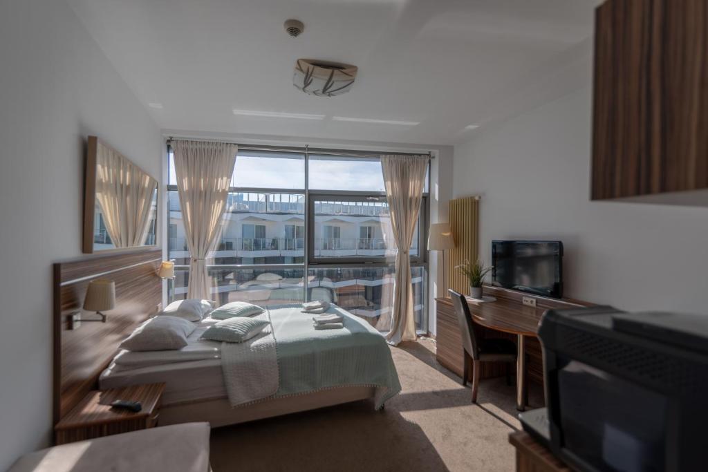 科沃布热格ARKA APARTAMENT DELUXE 723b的一间卧室，里面有一张床和一扇大窗户。