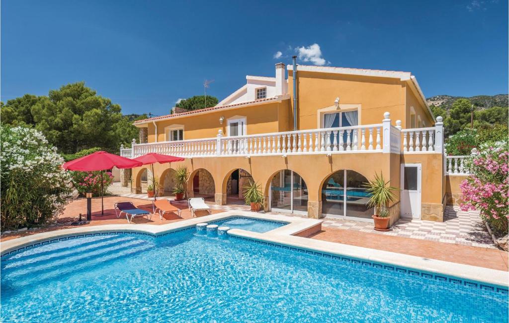 a villa with a swimming pool in front of a house at Stunning Home In Torremanzanas With 4 Bedrooms, Wifi And Outdoor Swimming Pool in Torremanzanas