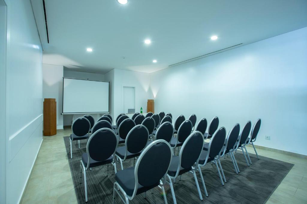 a conference room with chairs and a projection screen at Monte Santo Resort in Carvoeiro