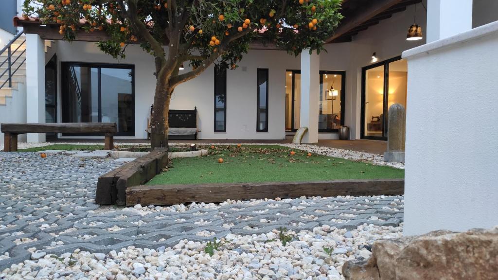 un edificio con un árbol en medio de un patio en LARANJEIRA das LOIRAS, en Óbidos