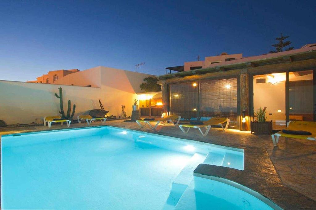 a swimming pool in front of a house at night at V PRINCESA Piscina y BBQ para max 10 personas in Puerto del Carmen