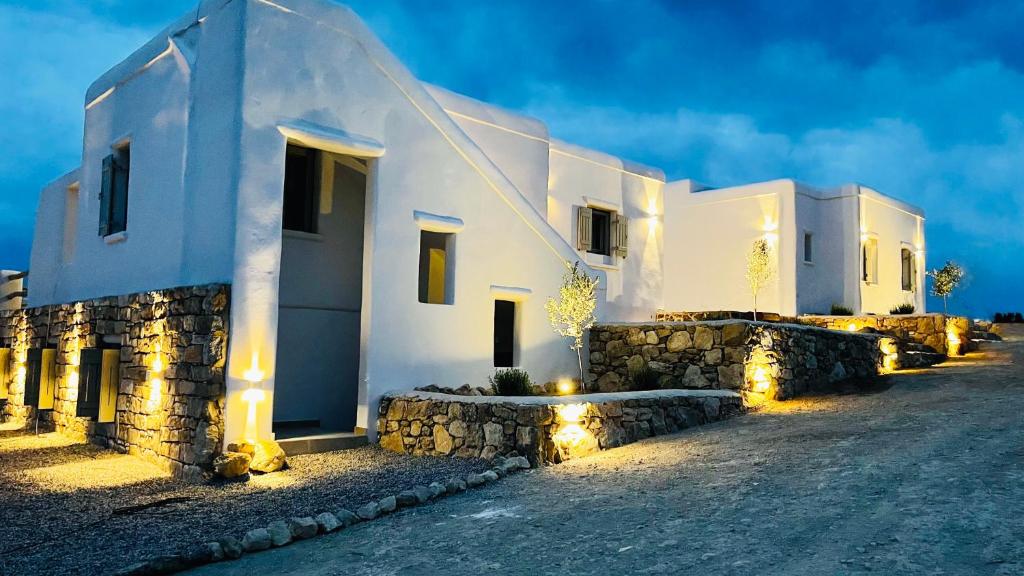 una fila de casas blancas con luces en una calle en Aeris suites pori semi basement villa en Koufonisia