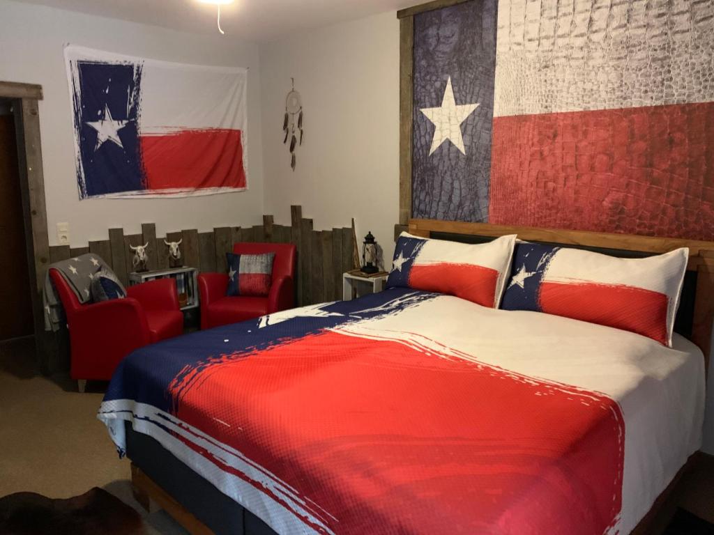 Un dormitorio con una cama y una bandera americana en la pared en Longhorn Ranch Countryhotel - Garni, en Schönau